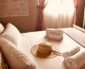 a straw hat sitting on a bed with towels at Az. Agr. Parco dei Buoi in Larino