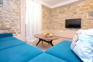 a living room with a blue couch and a table at Apartment Dvor in Split