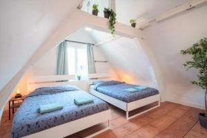 Un dormitorio abuhardillado con dos camas y una ventana. en Antwerp Old Town Apartment, en Amberes 27 fotos más