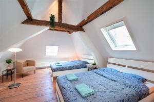 a attic bedroom with two beds and a chair at Antwerp Old Town Centrum Apartment in Antwerp