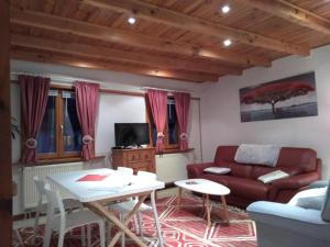 a living room with a couch and a table at Gites Aux Fines Bulles d'Alsace SPA privatif en supplément in Bergheim