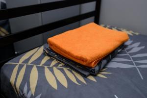 Una toalla naranja está sentada encima de una cama en U-First en Kiev
