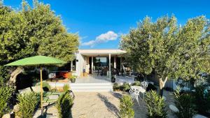 dom z zielonym parasolem, krzesłami i drzewami w obiekcie Buqez Eco Resort - Beach Villa No 29 - Seaview w mieście Drage