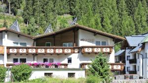 a building with a balcony with flowers on it at Mountain Apartments - living by Salner in Ischgl