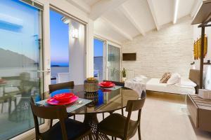 jadalnia i salon ze stołem i krzesłami w obiekcie Porta del Golfo Apartments & Suites w mieście Castellammare del Golfo
