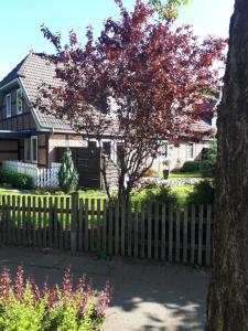 una valla de madera frente a una casa con un árbol en Sonnenschein en Uelzen