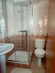 een badkamer met een douche, een toilet en een wastafel bij Casa da Sao in Nazaré