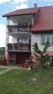 Una casa con flores en el balcón. en Świerkowy Zakątek, en Krasnobród
