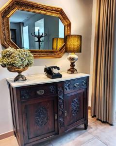 a mirror on top of a wooden dresser with a lamp at Villa Tauria- Casa de campo em aldeia medieval in Sabugal