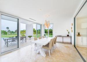 a dining room with a white table and chairs at Luxury 5-room modern villa with movie theater at exclusive Punta Cana golf and beach resort in Punta Cana