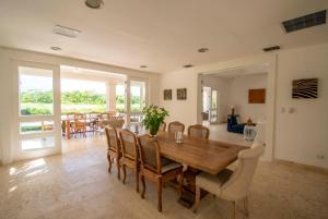 a dining room with a wooden table and chairs at Golf-front villa with large spaces, staff and pool, situated in luxury beach resort in Punta Cana