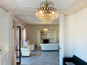 a living room with a chandelier and white furniture at Spazioso appartamento in centro Città in San Benedetto del Tronto