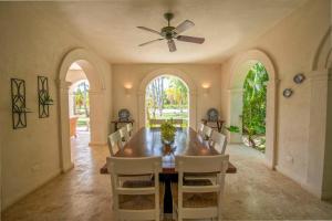 a dining room with a table and a ceiling fan at Luxury golf villa with private pool and service staff in exclusive resort near private beach in Punta Cana