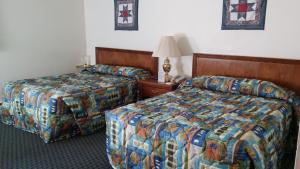 una camera d'albergo con due letti e una lampada di Cascades Lodge a Killington