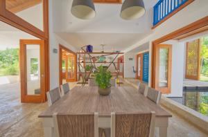 a dining room with a wooden table and chairs at Amazing 4-bedroom tropical villa with private pool and golf course view at luxury resort in Punta Cana