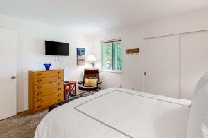 ein weißes Schlafzimmer mit einem Bett und einem TV in der Unterkunft Valley Gem in Sun Valley