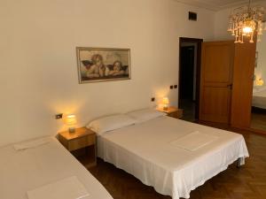 two beds in a room with two lamps on tables at Spazioso appartamento in centro Città in San Benedetto del Tronto
