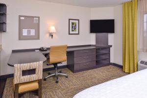 a hotel room with a desk with a computer and a television at Candlewood Suites Paducah, an IHG Hotel in Paducah