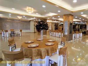 Hotel Mary Carmen في أمباتو: غرفة طعام مع طاولة وكراسي في مبنى