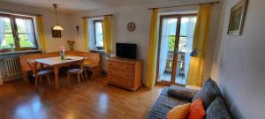 a living room with a couch and a table with a tv at Zum Heisn in Lenggries