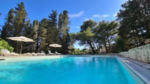 a swimming pool with chairs and umbrellas at Masseria Artemisia in Torre San Giovanni Ugento +29 photos