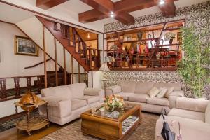 a living room filled with furniture and a fire place at Pousada D'lines in Campos do Jordão