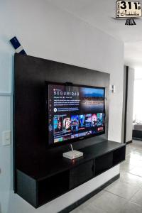 a flat screen tv sitting on top of a black entertainment center at Apartamento Cerca Al Parque Del Cafe con piscina in Montenegro