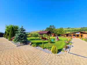 a garden with a gazebo and a house at Pensiunea Aida in Gura Humorului