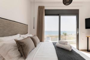 a bedroom with a large bed with a large window at Grand Blue Villas Lachania in Lachania +39 photos