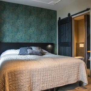 sypialnia z łóżkiem i zieloną ścianą w obiekcie Eigenheimer B&B w mieście Simpelveld