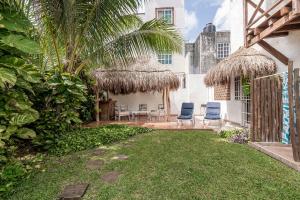 a backyard with a patio with chairs and a house at Casa Nona Azul in Cancún