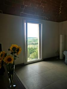 a room with a window and a vase of flowers at La casa di Isola in Peccioli