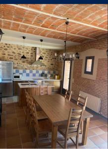 a kitchen with a wooden table and some chairs at Casa Rural San Isidro in Valdepiélagos