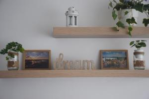 a shelf with two pictures and a sign that says dream at Feel Danube apartment in Zemun