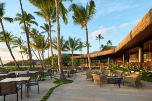 a patio area with tables, chairs and umbrellas at Ka'anapali Beach Hotel in Lahaina
