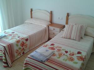 two beds sitting next to each other in a room at Apartamento junto al mar in Bellreguart