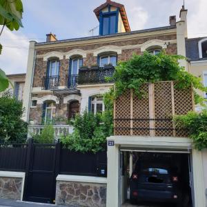 un bâtiment avec une voiture garée devant lui dans l'établissement Hier et Aujourd’hui 21, à Malakoff