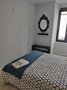 a bedroom with a bed with a mirror on the wall at Long Beach Apartamento AL in Praia da Vitória