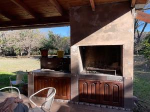 - un barbecue extérieur avec une table et des chaises sur la terrasse dans l'établissement Naturaleza Pura Casa La Caldera, à Salta