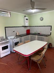 una cucina con tavolo e sedie bianchi di Naturaleza Pura Casa La Caldera a Salta