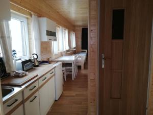 a kitchen with white cabinets and a wooden floor at Agroturystyka Bogdanki in Stary Targ