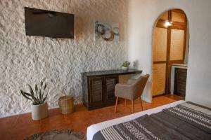 1 dormitorio con 1 cama y TV en la pared en Hotel Macondito Holbox, en Isla Holbox