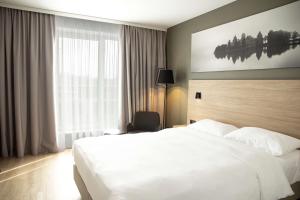 a hotel room with a white bed and a window at Park Inn by Radisson Vilnius Airport Hotel & Conference Centre in Vilnius