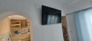 telewizor z płaskim ekranem na ścianie w pokoju w obiekcie Studio Pescador w mieście Olhão