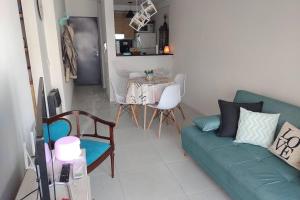 sala de estar con sofá verde y mesa en departamento céntrico relax en Rosario
