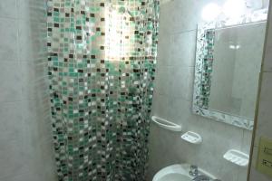 La salle de bains est pourvue d'une douche, d'un lavabo et d'un miroir. dans l'établissement Depto con fantástica TERRAZA PRIVADA en pleno centro, à Córdoba