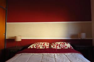 - une chambre dotée d'un lit avec un mur rouge dans l'établissement Depto con fantástica TERRAZA PRIVADA en pleno centro, à Córdoba