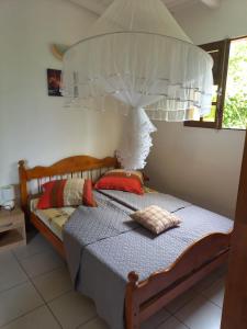 une chambre avec un lit à baldaquin dans l'établissement VILLA AMANDINE, à Saint-François