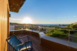 een balkon met twee blauwe stoelen en de zon bij Best Western Montecristo-Bastia in Bastia