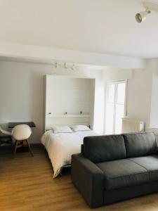 a bedroom with a bed and a couch at Studio close from train station and shops in Luxembourg